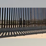 Mexican children look through the border fence into Santa Teresa, New Mexico