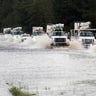 A convoy of utility trucks to assist with damage caused by Florence makes its way through Hwy 70 east of Kinston,  Saturday 