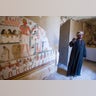 An Egyptian guard stands next to a funeral mural inside a newly discovered tomb on Luxor's West Bank