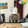 A student plays a board game with counselors and staff at the KS Relief Center in Yemen.