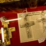A metal pectoral cross just like the one Pope Francis wears is displayed in Raniero Mancinelli's tailor shop in Rome, Thursday Feb. 13, 2014. 