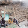 Jake Rath, middle, and Marine veteran Cpl. Kionte Storey sit with one of their guides during the climb up Mount Kilimanjaro.