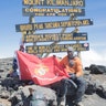 Marine veteran,Cpl. Kionte Storey at Uhuru Peak the summit of Mount Kilimanjaro at 19,341 feet, with a Marine Corps flag.