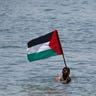 Swimmer Holds Palestinian Flag Protesting Israel