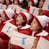 North Korea supporters wave the Korean unification flag prior to the women's hockey game