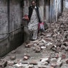 A man walks past the rubble 