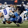 Dallas Cowboys quarterback Tony Romo (9) fumbles as he is tackled by Detroit Lions defensive end Darryl Tapp (52)