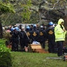 Rescue team wait to remove the bodies of a mother and child, killed by a falling tree in Wilmington, North Carolina, Friday