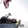 Pearl Harbor survivors toss a commemorative wreath off the fantail of the USS Intrepid 