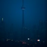 The moon rises over the CN Tower and skyline in Toronto, Ontario, December 2