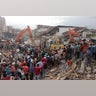 Rescuers use excavators to search for victims under the rubble of collapsed buildings after an earthquake in Pidie Jaya, Aceh province, Indonesia.