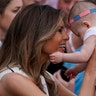 First Lady Melania Trump holds a baby during the Congressional Picnic at the White House, Thursday