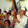 In this Oct. 5, 1989 file photo, Gen. Manuel Noriega holds a rifle bearing his name, given to him by a supporter during a pro-government rally, in Santiago, Panama.
