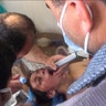 A Syrian doctor treats a boy.