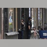 Police officers stand in a doorway at the scene.