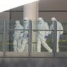 Police forensic investigators walk along a bridge linking Victoria Station with the Manchester Arena 