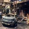 Iraqi security forces and civilians inspect the site of the deadly bombing in Baghdad