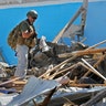 An unidentified armed member of foreign security personnel examines the scene of a car bomb attack in Mogadishu, Somalia 