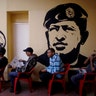 Voters wait to cast their ballots next murals of Venezuelan Independence hero Ezequiel Zamora, left, and Hugo Chavez, at a polling station