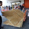 People load sheets of plywood into their car at The Home Depot store in North Miami, Fla., Wednesday