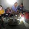 The Blinckman family use their personal devices while sheltering in a stairwell utility closet as Hurricane Irma goes over Key West, Fla., Sunday