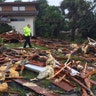 Palm Bay officer Dustin Terkoski walks over tornado damage to a home in Palm Point Subdivision in Brevard County, Fla., Sunday
