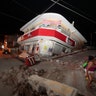 A woman walks past a collapsed building after a 7.1 earthquake, in Jojutla, Morelos state, Mexico, Tuesday