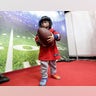 Jesus Cardenas Jr., 2, carries a football as he walks through an exhibit at the NFL Experience.