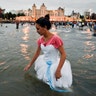A woman releases a small boat as an offering for the African sea goddess Yemanja, at a beach in Montevideo, Uruguay