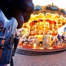 A German police officer stands next to a merry-go-round in the Christmas market in Frankfurt, Germany, Tuesday, Dec. 20, 2016 one day after a truck ran into a crowded Christmas market in Berlin killing several people.