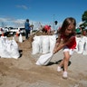 Chloe Heeden drags a sandbag to her father's car in Virginia Beach, Virginia, Wednesday