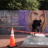 An artist works on a mural of car attack victim Heather Heyer prior to a memorial service 