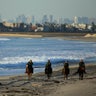 U.S. Border Patrol agents on horseback patrol along a beach just north of the U.S.-Mexico border near San Diego, California.