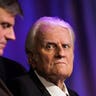 Rev. Billy Graham and his son Franklin Graham wait for the start of a service in New Orleans, March 12, 2006