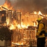 A firefighter monitors a house burning in Santa Rosa