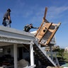 Felix Tijerina, right, and Andy Guerra, left, try to salvage items from their family home that was destroyed in the wake of Hurricane Harvey