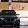 A man fills his car up at a gas station in Miami as the windows of the station were boarded up on Wednesday