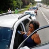 Yugonda Sample waits outside of her car as traffic backs up in Newport News, Virginia as people attempt to pickup sandbags, Wednesday