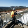 Jason Newton, of the Department of Water Resources, takes a picture of water going over the emergency spillway at Oroville Dam in Oroville.