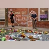 Jason Charter, left, of Washington, stands at a memorial