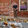 Jason Charter, left, of Washington, stands at a memorial