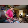 Laura Gill looks at family photos drying from their home that was flooded during Tropical Storm Harvey, Wednesday, in Baytown, Texas