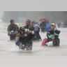 Isiah Courtney carries his dog Bruce through flood waters from Tropical Storm Harvey in Beaumont Place, Houston, Texas, Monday