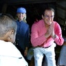 UNICEF Goodwill Ambassador, Roger Moore, and his wife greet a child at a village in Cambodia on Penh on October 23, 2003