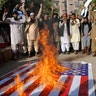 Pakistanis burn a representation of the U.S. flag during a protest rally in Hyderabad, Pakistan, December 7