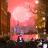 People watch as fireworks explode over the Kremlin standing at Red Square blocked by police during New Year celebrations in Moscow, Russia, Sunday, Jan. 1, 2017. 
