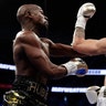 Floyd Mayweather Jr., left, hits Conor McGregor during their super welterweight boxing match