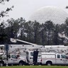 The 'Spaceship Earth' dome looms above a fleet of utility trucks parked in a parking lot at Disney's Epcot theme park