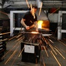 A Household Cavalry farrier fashions a horse shoe in the blacksmith shop at the unit's barracks in London, May 9, 2018