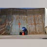 A woman talks to her relatives across a fence separating Mexico and the United States, in Tijuana, Mexico.